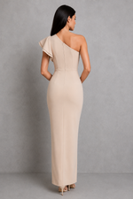 Woman wearing a beige one-shoulder dress against a gray background