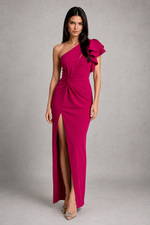 Woman wearing a pink one-shoulder dress with a slit on a gray background