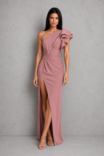 Woman wearing a one-shoulder pink dress with a slit on a gray background