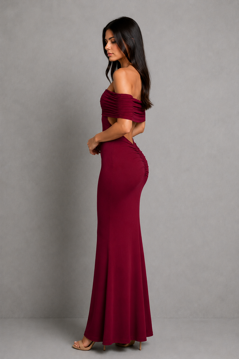 Woman wearing a burgundy off-shoulder gown against a gray background