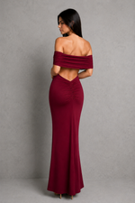 Woman wearing a burgundy off-shoulder gown against a gray background