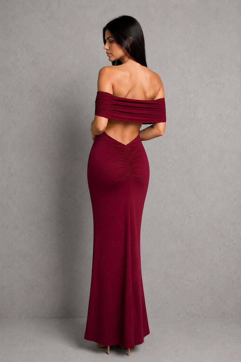 Woman wearing a burgundy off-shoulder gown against a gray background