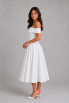 Woman wearing a white off-shoulder dress against a gray background