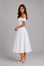 Woman wearing a white off-shoulder dress against a gray background