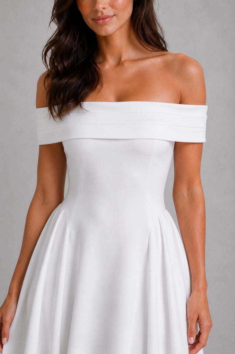 Woman wearing a white off-shoulder dress against a gray background