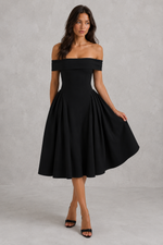 Woman wearing a black off-shoulder dress against a gray background