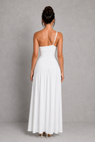 Woman wearing a white dress against a gray background