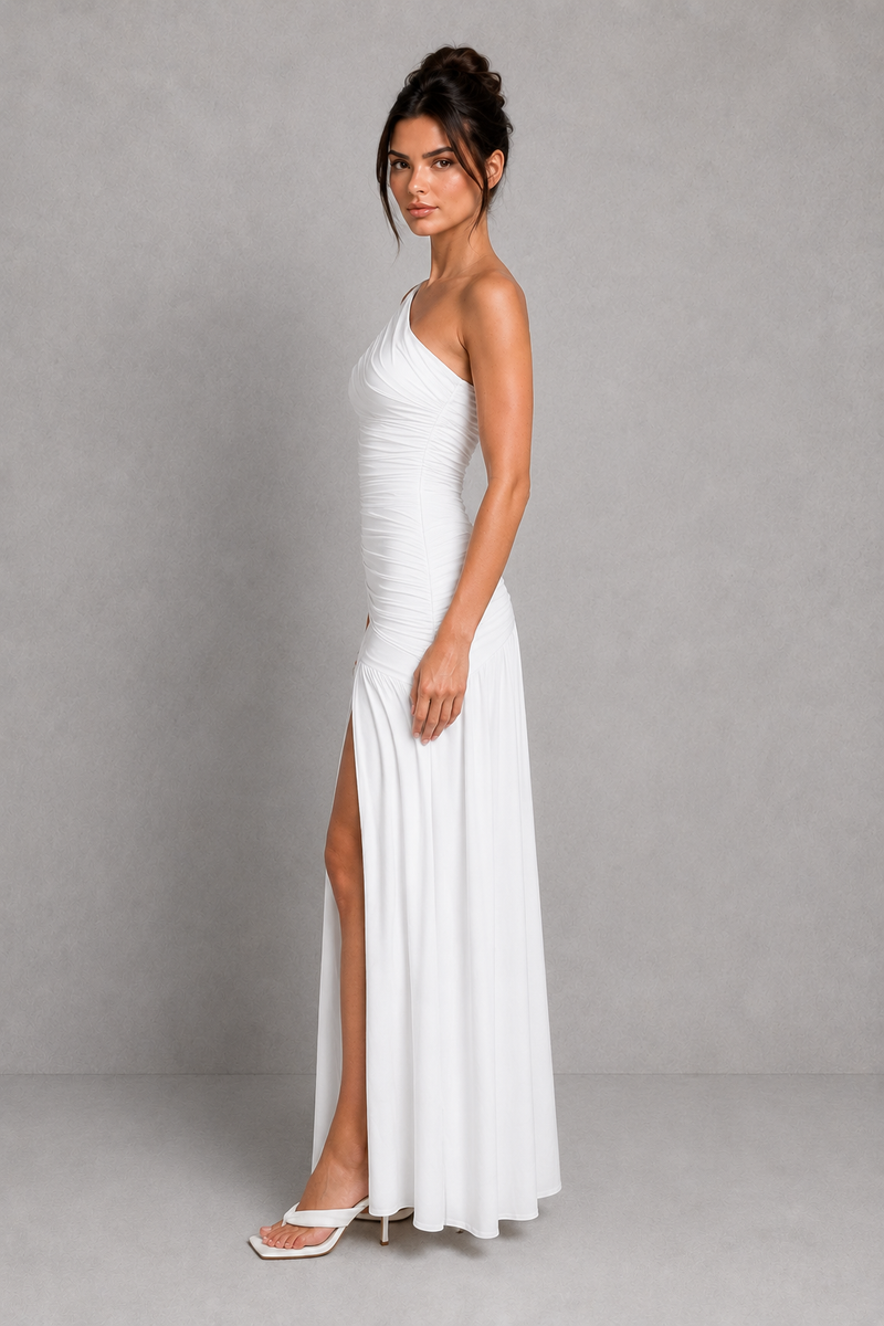 Woman wearing a white one-shoulder dress with a slit on a gray background