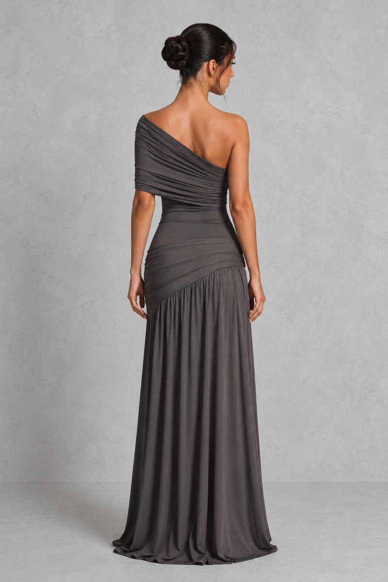 Woman wearing a gray one-shoulder dress against a plain background