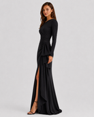 Black evening gown with long sleeves and a slit on a white background