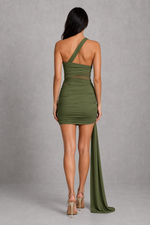 Woman wearing a green one-shoulder dress with a slit on a gray background