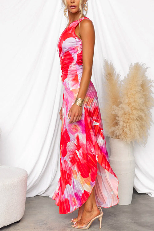 Woman wearing a colorful floral dress in a minimalistic setting with a vase and plant.