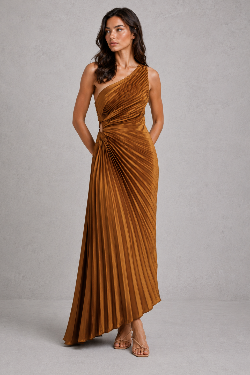 Woman wearing a brown one-shoulder dress against a gray background