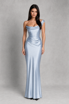 Woman wearing a light blue evening gown against a gray background