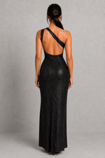 Woman wearing a black sequin evening gown with a gray background