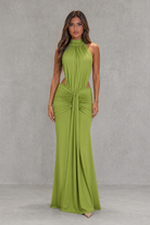Woman wearing a green dress against a gray background