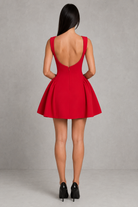 Red dress with open back worn by a person on a gray background
