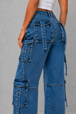 Blue cargo jeans with multiple pockets on a gray background