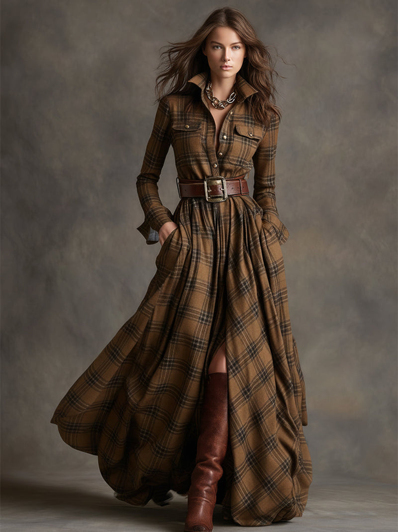 Woman wearing a long brown plaid dress with a belt and boots against a gray background