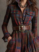 Plaid dress with a belt and gold chain detail on a neutral background