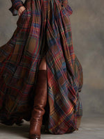 Person wearing a long plaid coat with a plain background