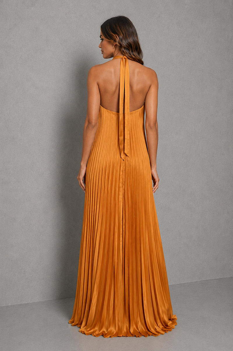 Women’s golden orange pleated halterneck maxi dress with a cross-front neckline, open back, and flowing floor-length silhouette for wedding guests and formal occasions
