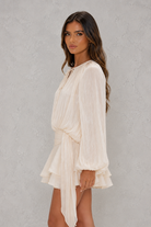 Woman wearing a white dress against a gray background