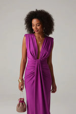 Woman wearing a vibrant purple dress against a plain background