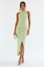 Woman wearing a light green dress with a stone wall background