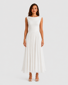 Woman wearing a white dress on a plain background