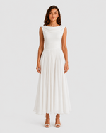 Woman wearing a white dress on a plain background
