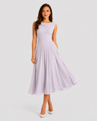 Woman wearing a light purple dress on a plain background