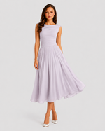Woman wearing a light purple dress on a plain background
