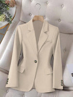 Beige blazer on a hanger against a neutral background