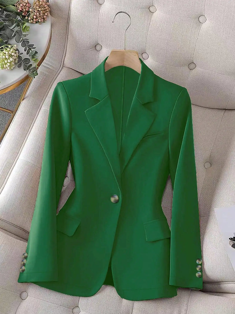 Green blazer on a hanger against a neutral background