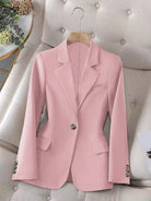 Pink blazer on a hanger against a neutral background