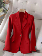 Red blazer on a hanger against a neutral background