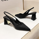 Black high-heeled shoes on a light background