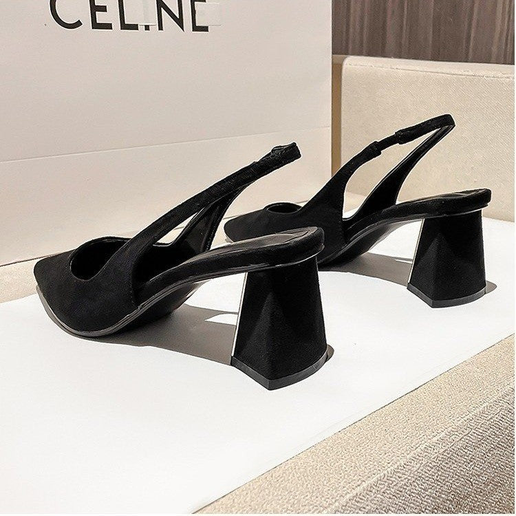 Black high-heeled shoes on a white surface with a blurred background