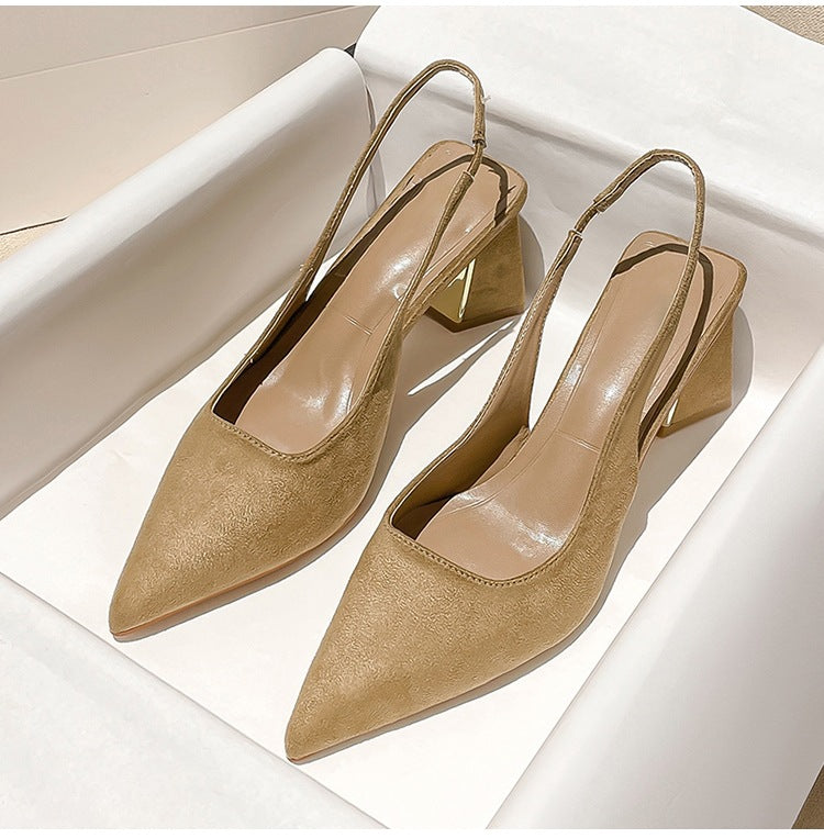 Pair of beige high-heeled shoes on a white surface