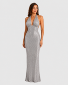 Woman wearing a white sequin dress on a plain background