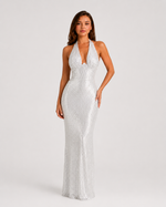 Woman wearing a white sequin dress on a plain background