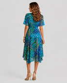 Woman wearing a blue patterned dress on a gray background