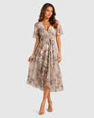 Woman wearing a floral dress on a plain background