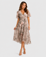 Woman wearing a floral dress on a plain background