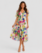 Woman wearing a colorful floral dress on a white background