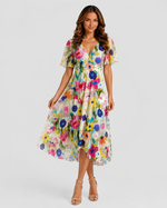Woman wearing a colorful floral dress on a white background