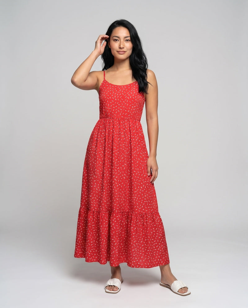 Woman wearing a red dress with white patterns on a gray background