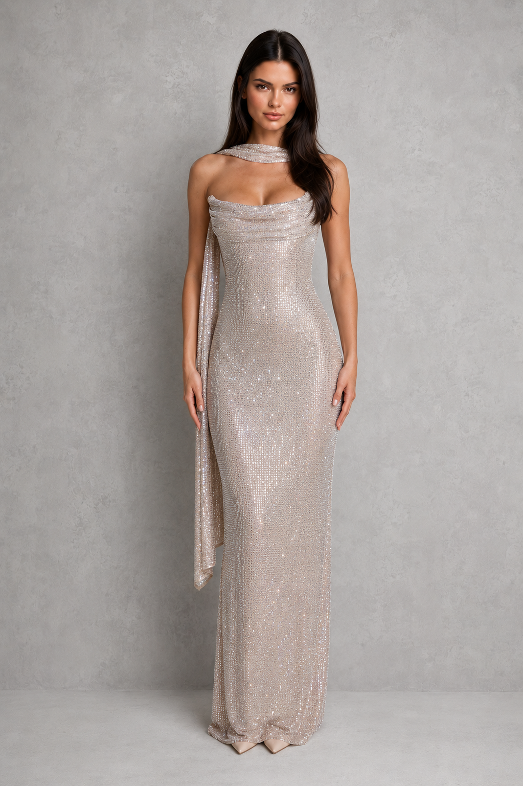 Woman wearing a silver strapless gown with a draped effect against a gray background
