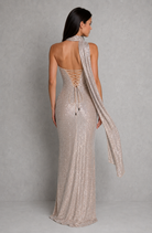 Woman wearing a sparkly evening gown with a plain background